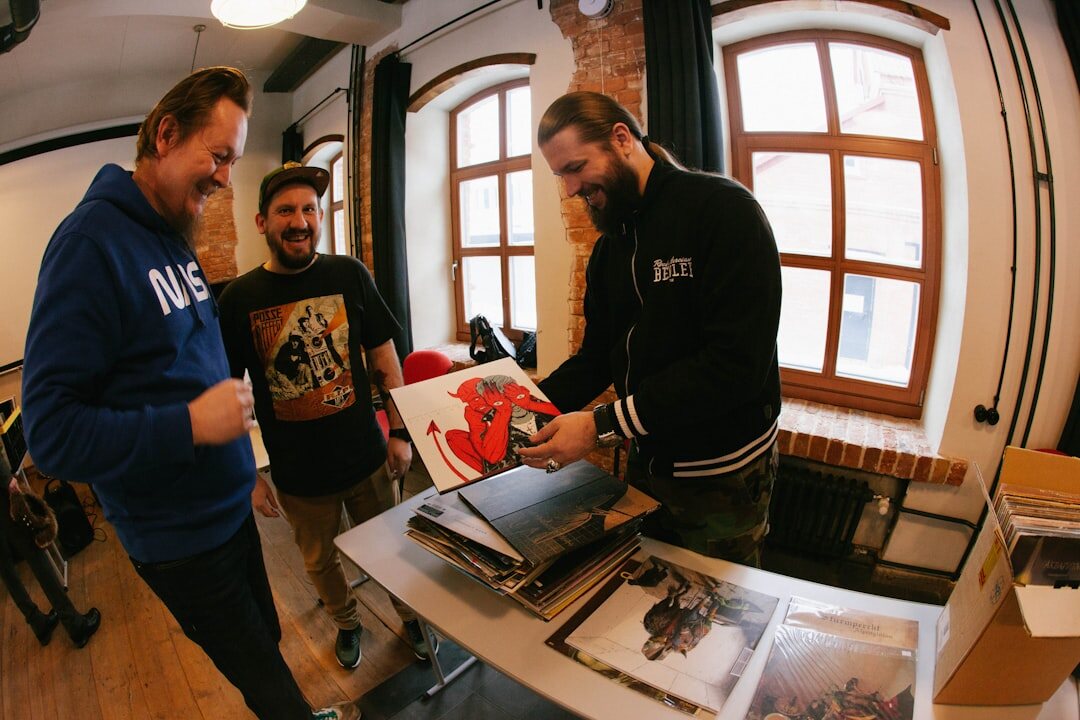 Small editorial team discussing printed television archive photos around a table